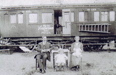 814024 Afbeelding van een gezin bij een oud rijtuig van de Staatsspoorwegen (S.S. A 69), ingericht als noodwoningen ...